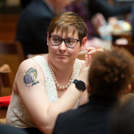 a person wearing a pearl necklace and a white dress