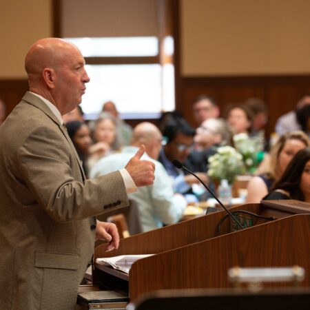a person giving a thumbs up at a podium