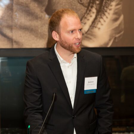 a person in a suit standing at a podium