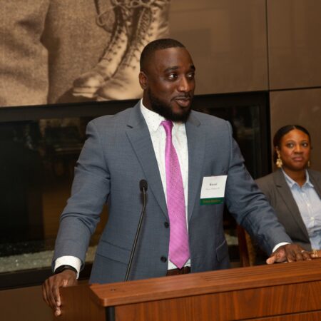 a person in a suit standing at a podium