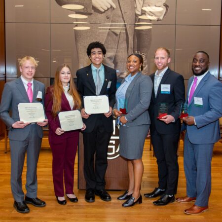 a group of people holding certificates
