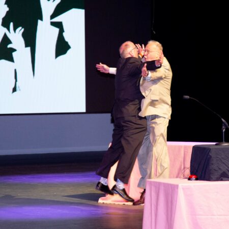 a couple of men kissing on stage