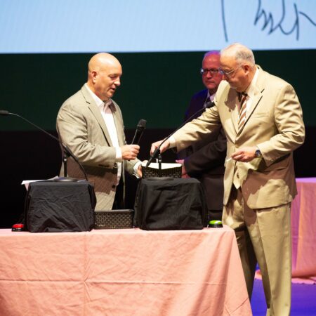 a person in a suit shaking hands with another person in a suit