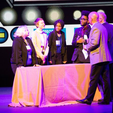 a group of people standing around a table