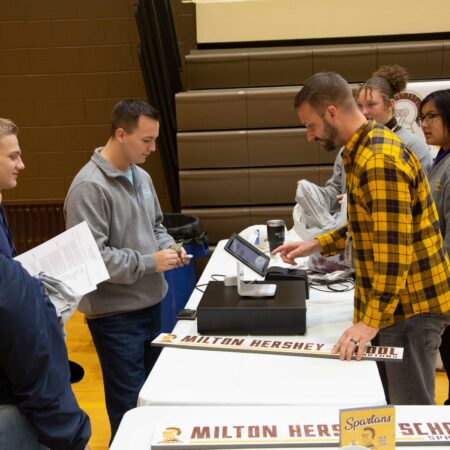 a group of people standing around a table