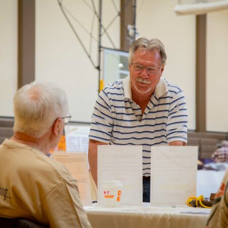 a person standing at a table with two men