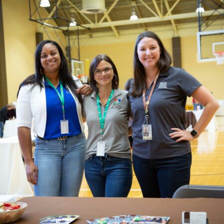 a group of women standing in a gym
