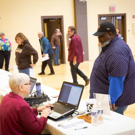 people at a table with a laptop