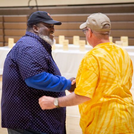 two men shaking hands in a room