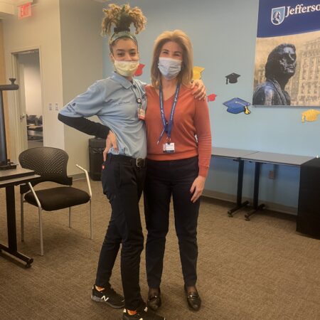 two women wearing masks posing for a picture