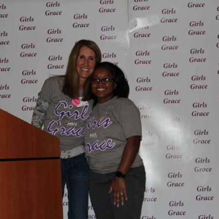 a person standing next to a person standing in front of a podium