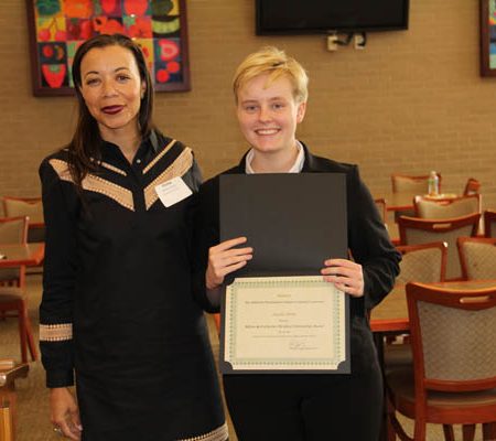 a person holding a certificate and smiling