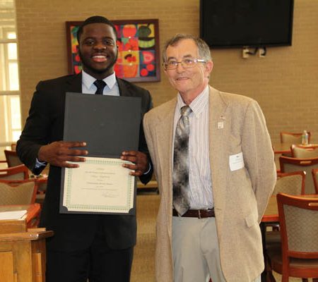 a person holding a certificate and smiling