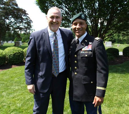 a person in a suit and tie standing next to a person in a military uniform