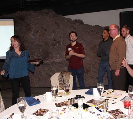 a group of people standing around a table