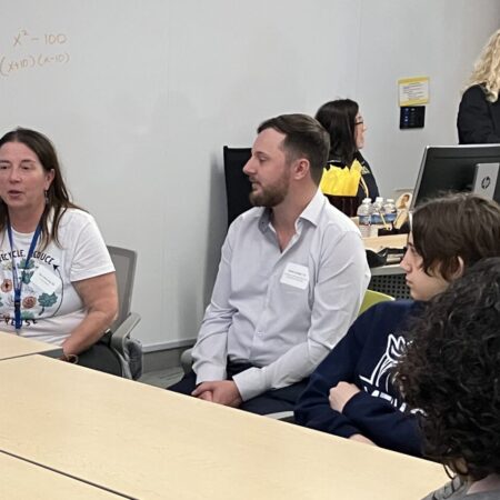 a person sitting in a room with people in the background