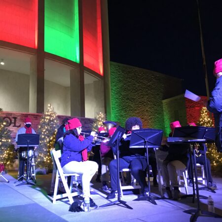 a group of people playing instruments outside of a building