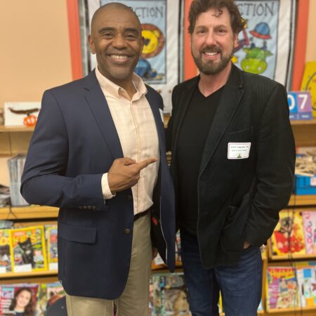 two men standing in front of a book store