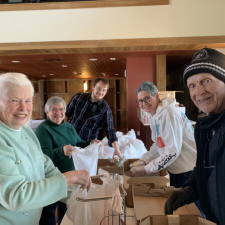 a group of people standing around a table with bags