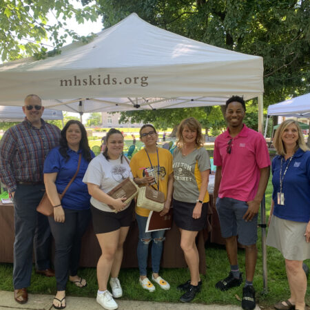 a group of people standing under a tent