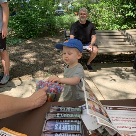 a child sitting at a table with a person in the background