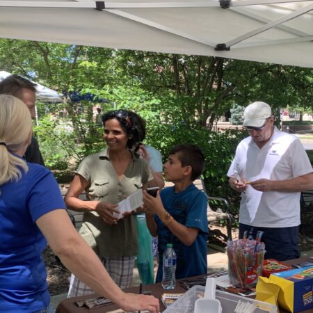 a group of people standing around a table
