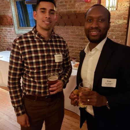 two men holding drinks posing for the camera