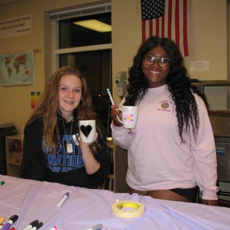 a couple of children holding mugs