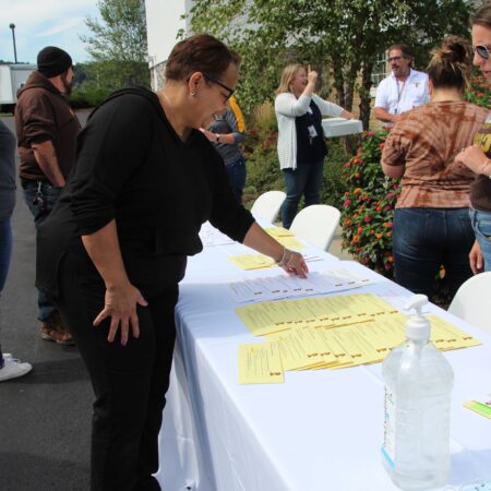 a person standing next to a table with yellow papers