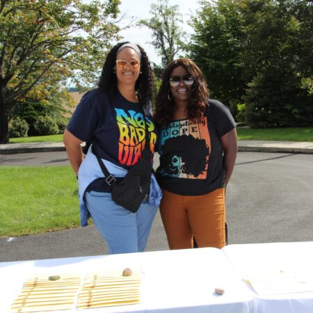 two women standing next to a table