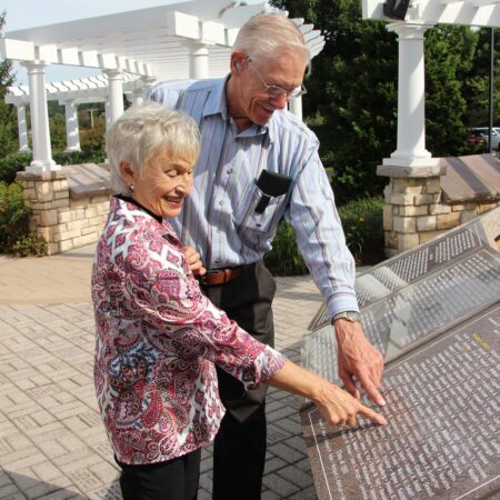 people pointing at a plaque