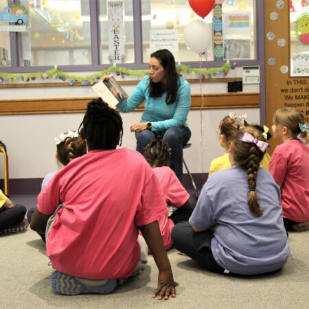 a person reading to children in a classroom