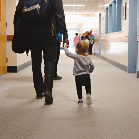 a person and child walking in a hallway