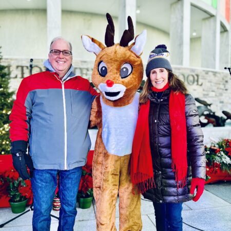 people standing next to a person in a reindeer garment