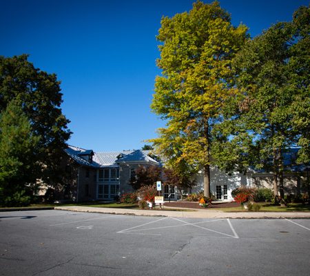 a parking lot with trees and a building