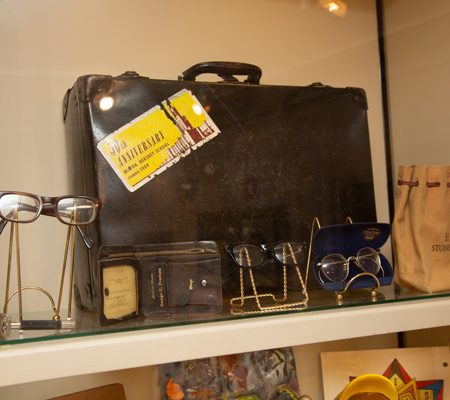 a suitcase and glasses on a shelf