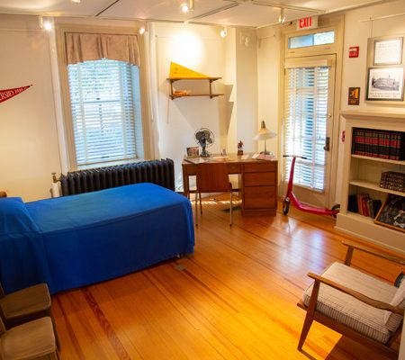 a room with a blue bed and a wood floor