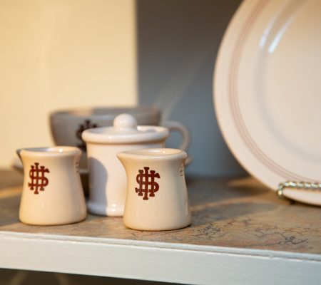 a white and red ceramic dishes on a shelf