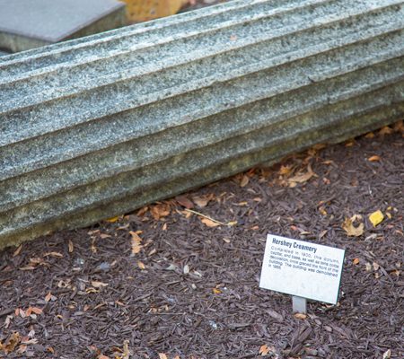 a sign on a post next to a stone pillar