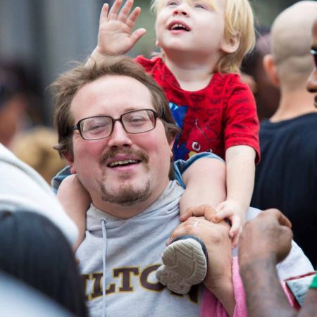 a person holding a child on his shoulders