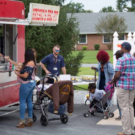 a group of people standing outside a food truck