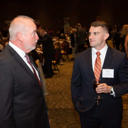 a person in suit and tie talking to another person
