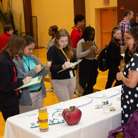 a group of people standing around a table