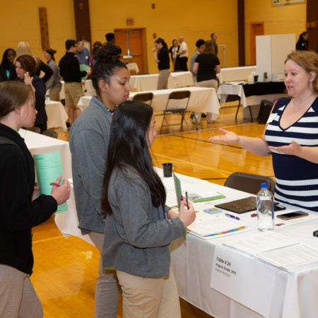 a group of people standing around a table
