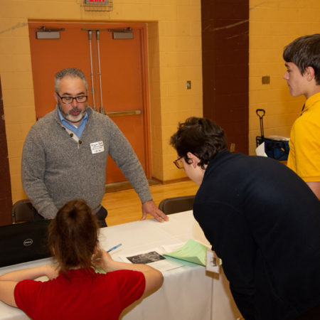 a group of people standing around a table