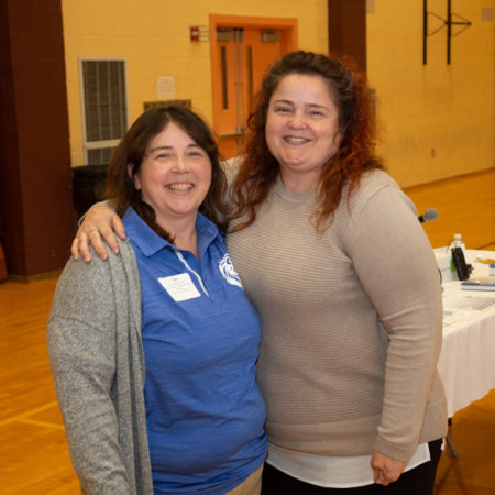 two women standing together smiling
