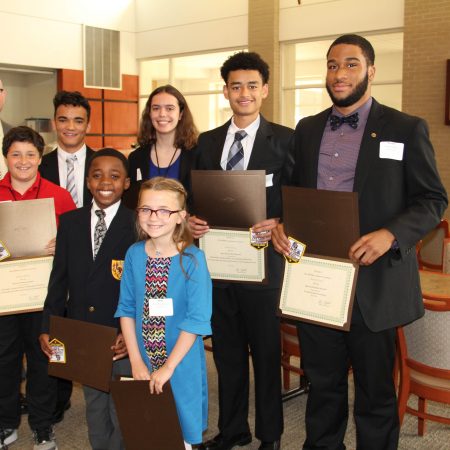 a group of people holding certificates
