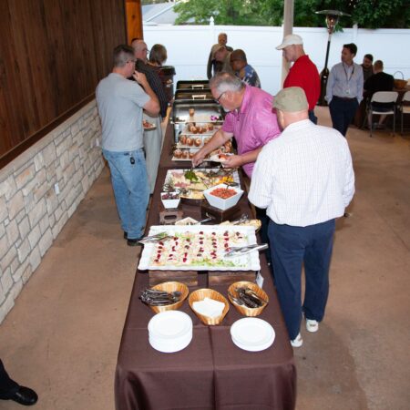 a group of people standing at a buffet