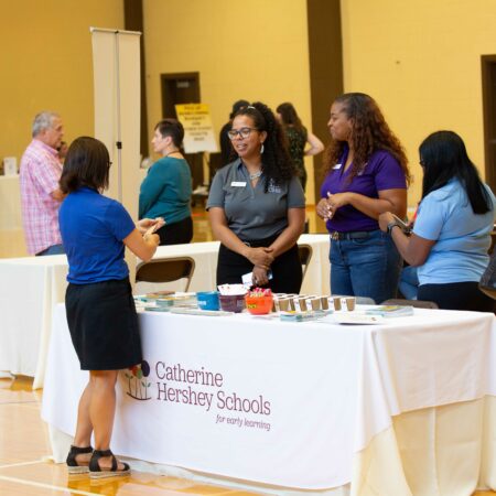 a group of people standing around a table