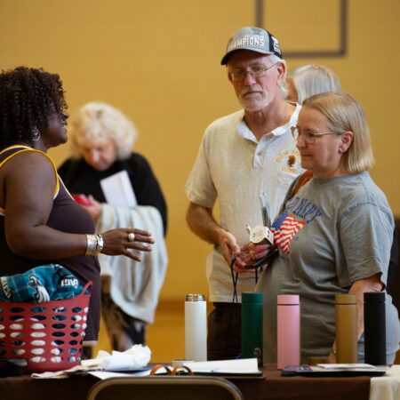 a group of people standing around a table